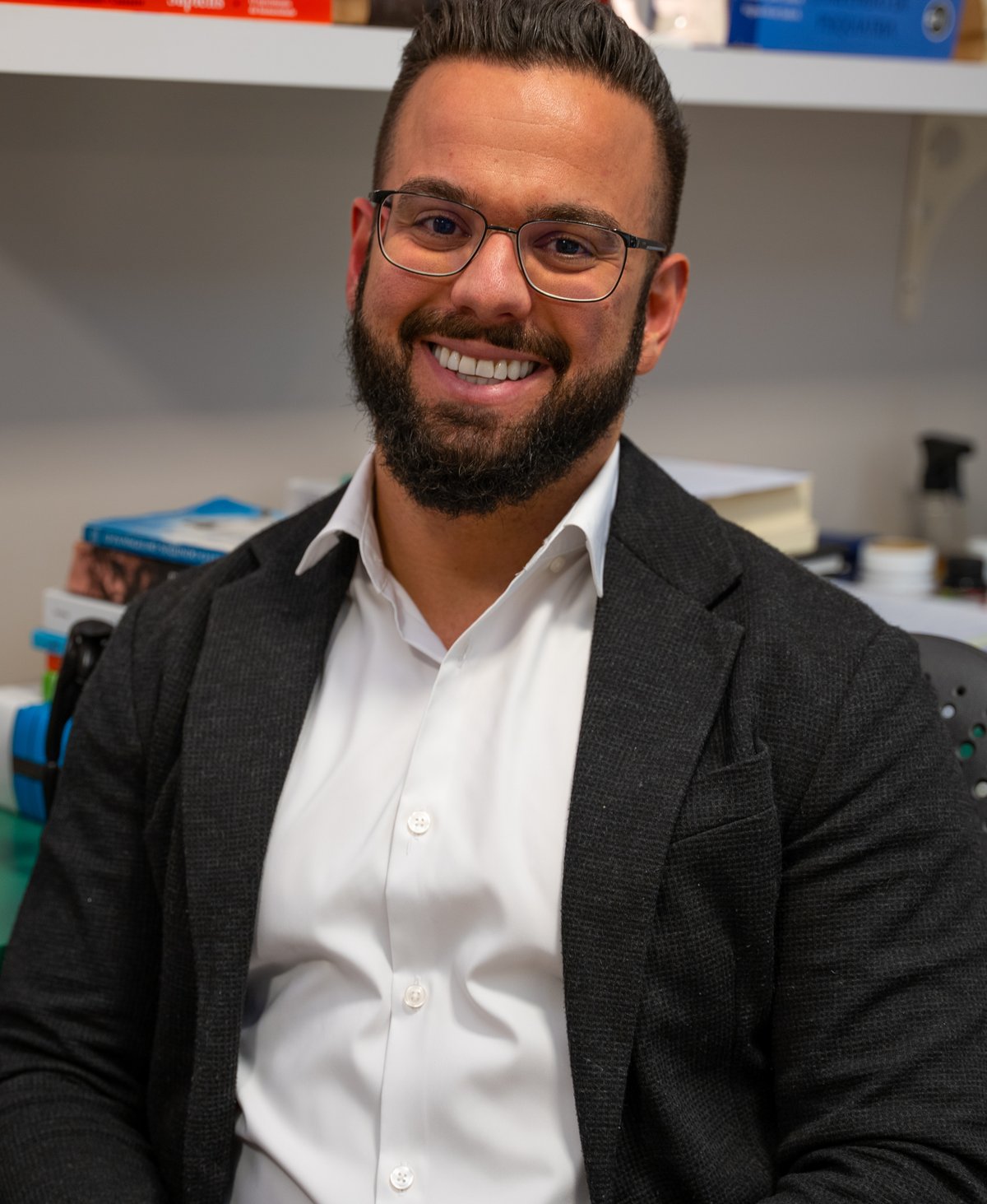Dr. Rafael Latorraca, psiquiatra, sorrindo em seu consultório